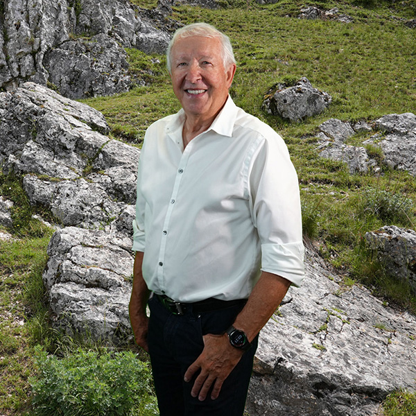 Close-up of Robert Picard, outdoors, in a white shirt, smiling.