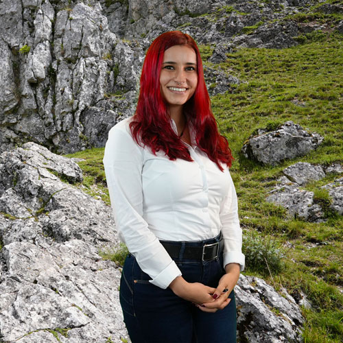 Close-up of Beatriz de Lima, outdoors, in a white shirt, smiling.