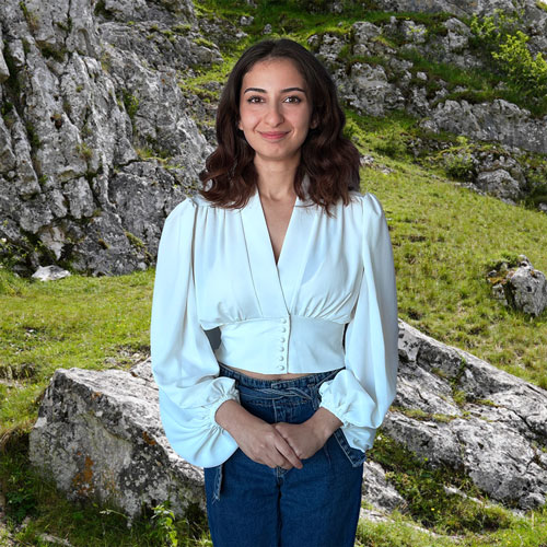 Close-up of Yaren Tekdemir, outdoors, in a white shirt, smiling.