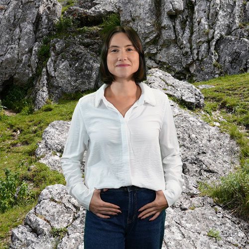 Close-up of Diana Borges, outdoors, in a white shirt, smiling.