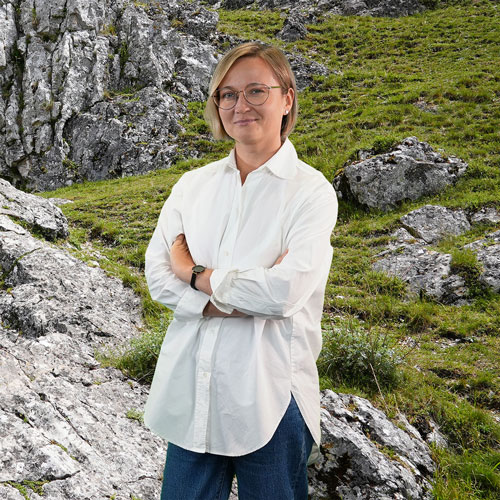 Close-up of Julia Zaitseva, outdoors, in a white shirt, smiling.