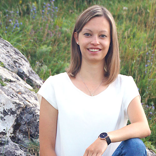 Close-up of Luisa Thumm, outdoors, in a white shirt, smiling.