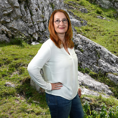 Close-up of Nicole Heim, outdoors, in a white shirt, smiling.