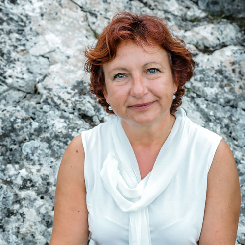 Close-up of Rudite Schillinger, outdoors, in a white shirt, smiling.