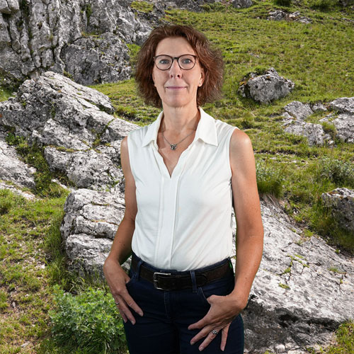 Close-up of Simone Groh, outdoors, in a white shirt, smiling.