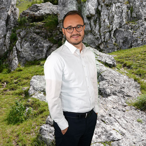 Close-up of Valentin Degenhardt, outdoors, in a white shirt, smiling.