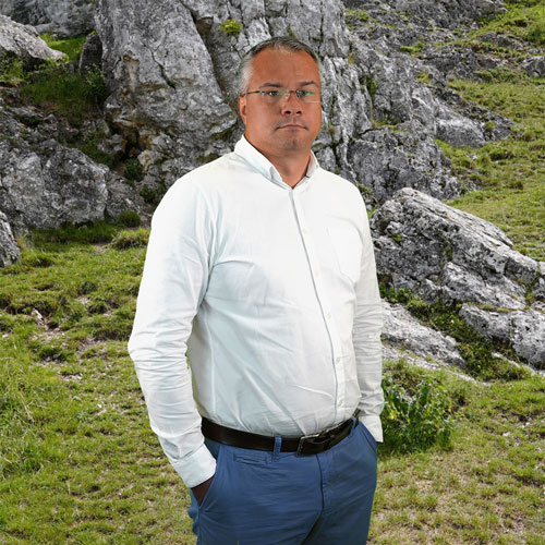 Close-up of Aleksandr Oblezov, outdoors, in a white shirt.