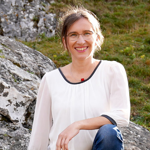 Close-up of Dr. Heidi Becker, outdoors, in a white shirt, smiling.