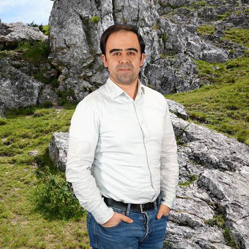 Close-up of Hugo Tavares, outdoors, in a white shirt, smiling.