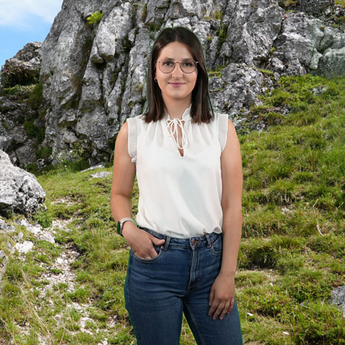 Close-up of Iva Gjolli, outdoors, in a white shirt, smiling.