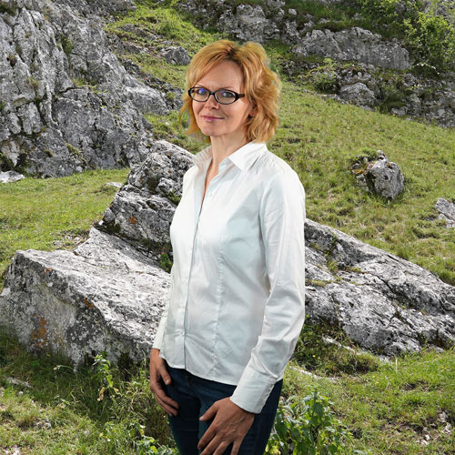 Close-up of Dr. Kerstin Tang, outdoors, in a white shirt, smiling.