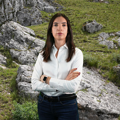 Close-up of Lenia Pereira, outdoors, in a white shirt.