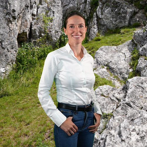 Close-up of Linda Zoccatelli, outdoors, in a white shirt, smiling.