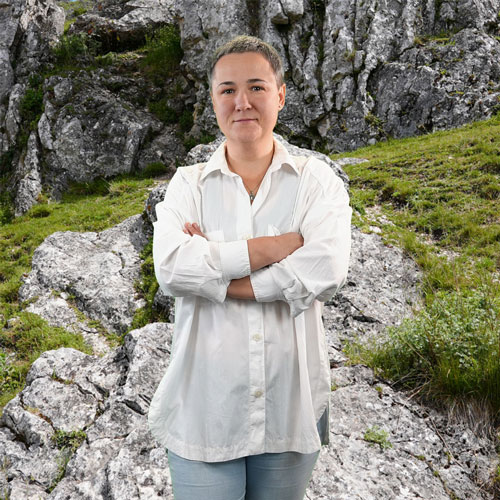 Close-up of Maryna Pokrovska, outdoors, in a white shirt, smiling.