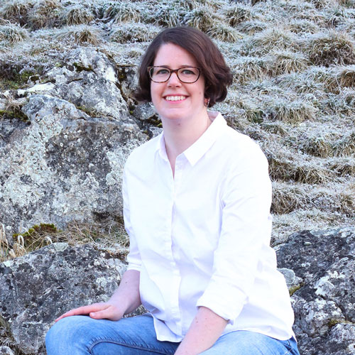 Close-up of Tanja Dreher, outdoors, in a white shirt, smiling.