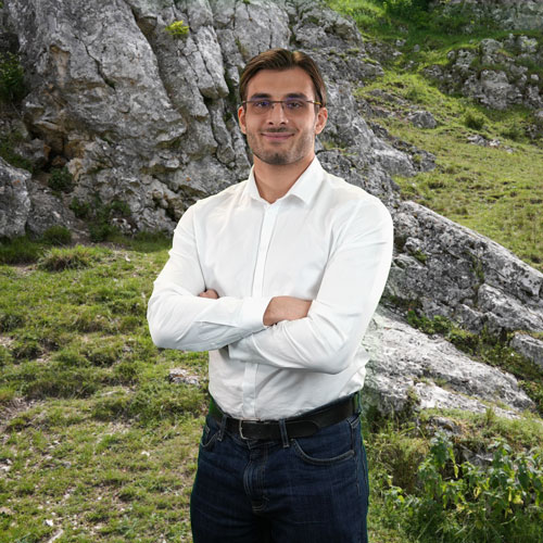 Close-up of Theo Andre, outdoors, in a white shirt, smiling.