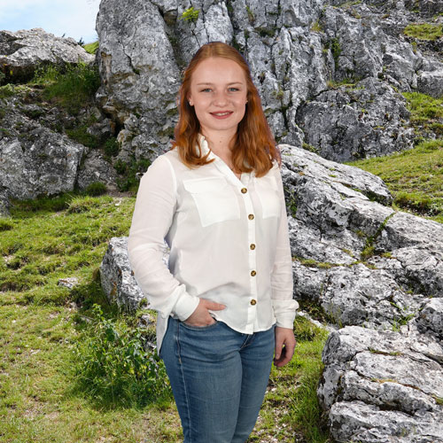 Close-up of Verena Winter, outdoors, in a white shirt, smiling.