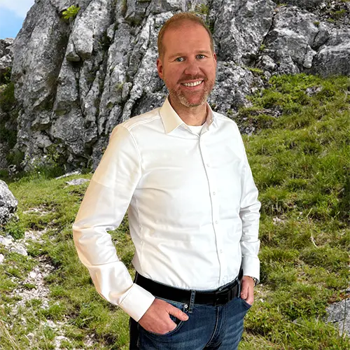 Close-up of Dr. Markus Lutz, outdoors, in a white shirt, smiling.