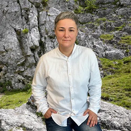 Close-up of Maryna Pokrovska, outdoors, in a white shirt, smiling.