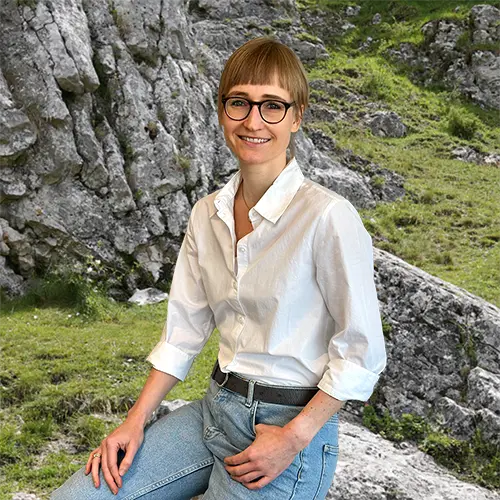 Close-up of Tina Seitz, outdoors, in a white shirt, smiling.